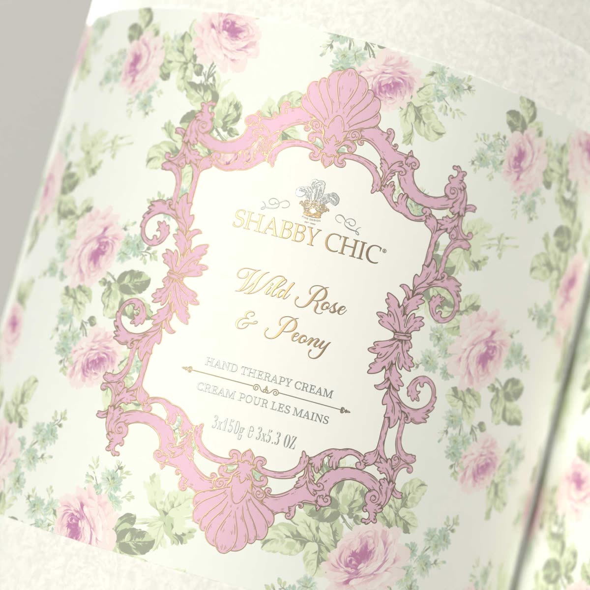 Close-up of a Shabby Chic label: a pink engraved frame around the crest and the scent name, on a rose pattern